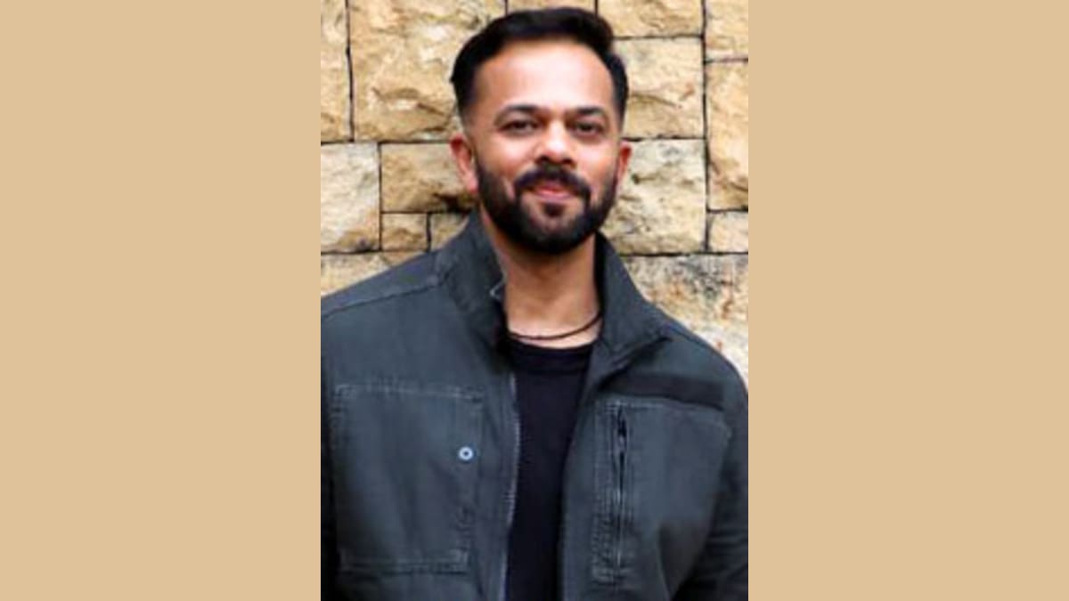 Modern man smiling outdoors in casual attire. Man smiling outdoors wearing a black jacket and casual clothes.
