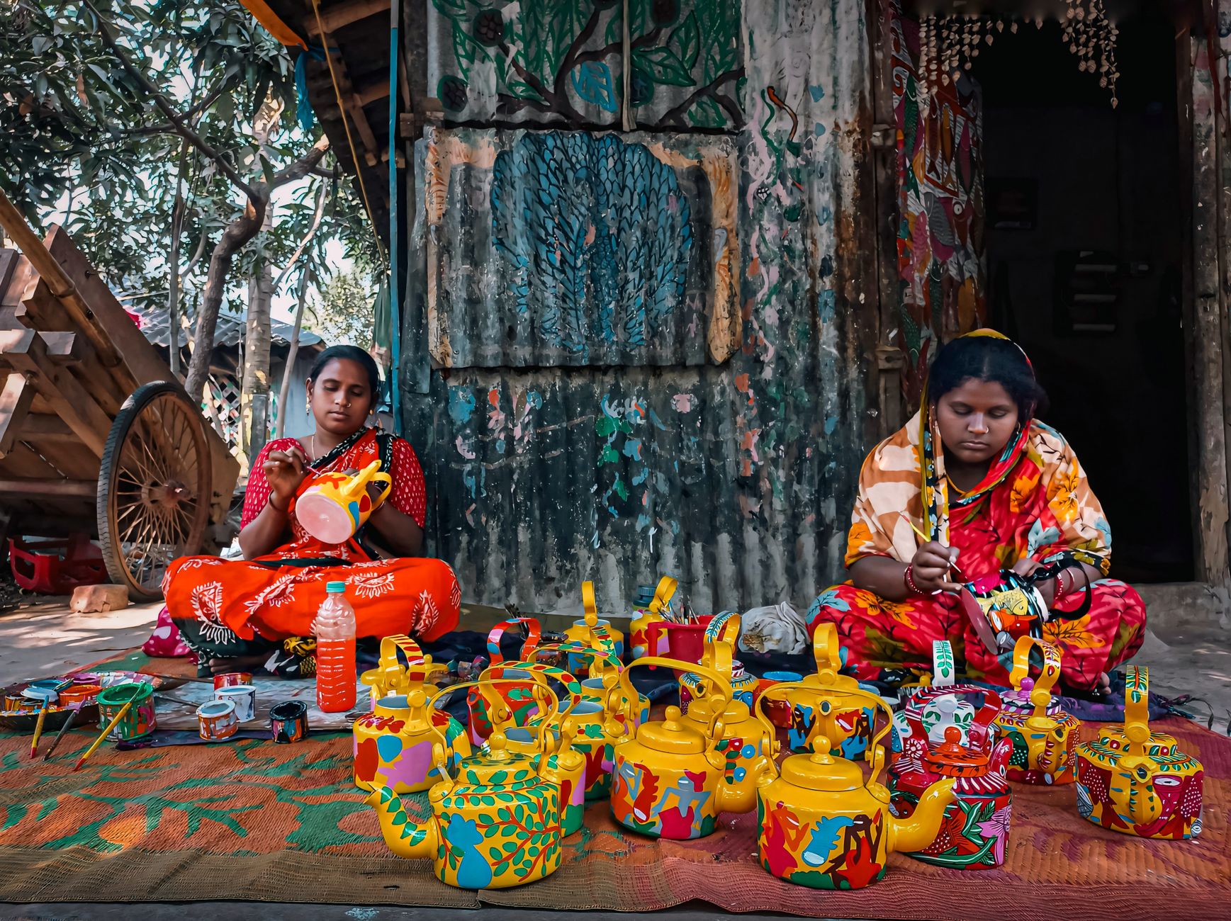 women painting kettles