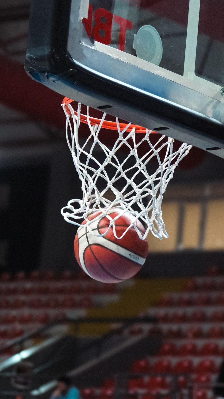 basketball swishing through hoop in indoor stadium