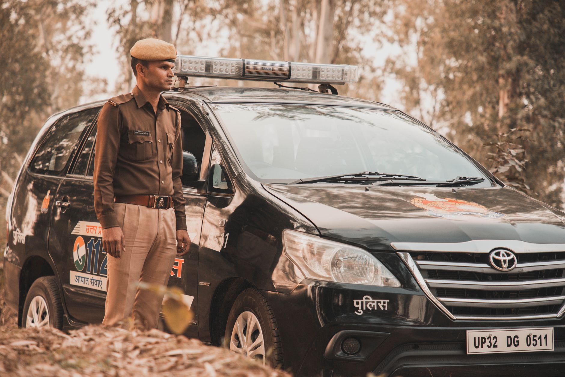 a policeman standing by a police car